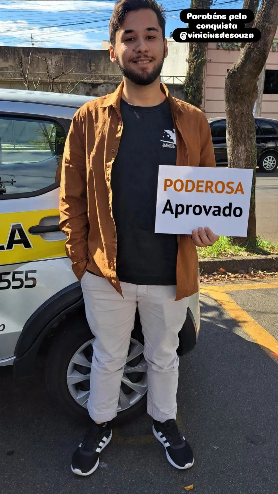 Aluno aprovado ao lado de carro da Auto Escola Poderosa