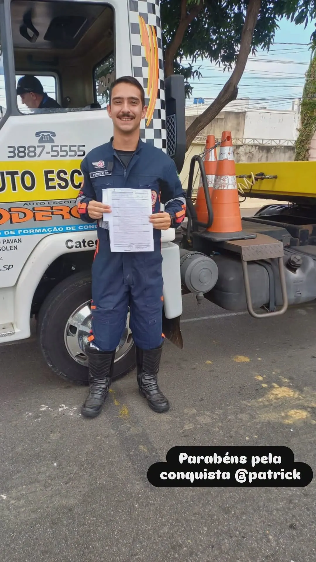 Aluno aprovado ao lado de caminhão da Auto Escola Poderosa