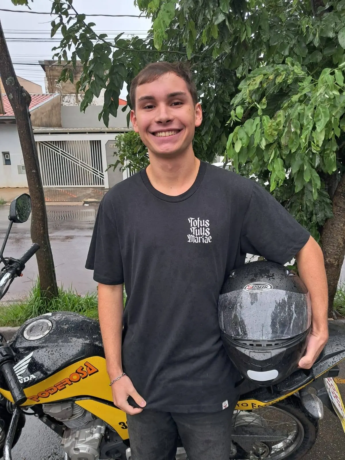 Aluno aprovado ao lado de motocicleta da Auto Escola Poderosa