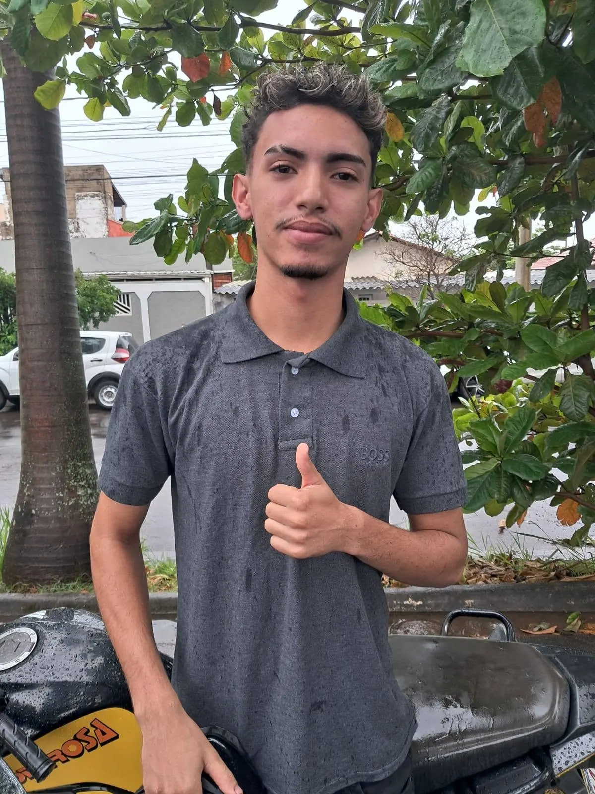 Aluno aprovado ao lado de motocicleta da Auto Escola Poderosa