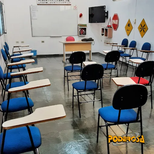 Sala de aula da Auto Escola Poderosa com cadeiras, mesa, quadro e sinalização